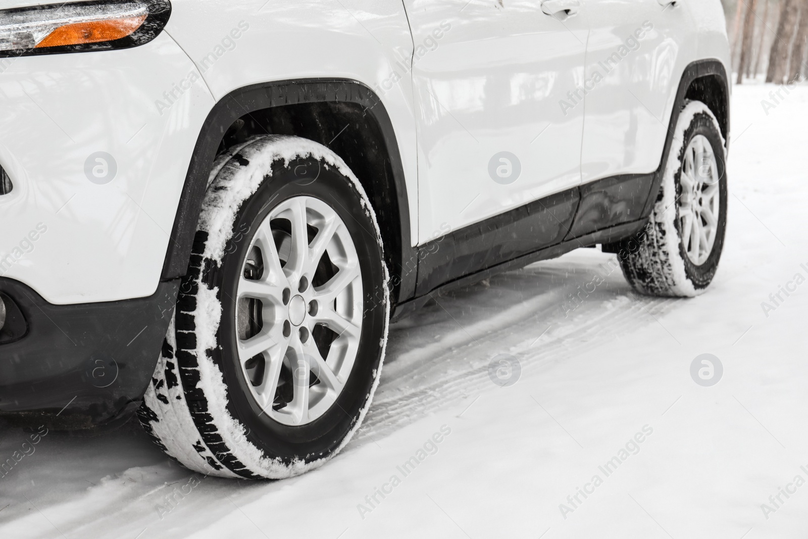 Photo of Modern car on snowy road, closeup view. Winter season