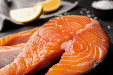 Photo of Fresh salmon steaks on table, closeup view