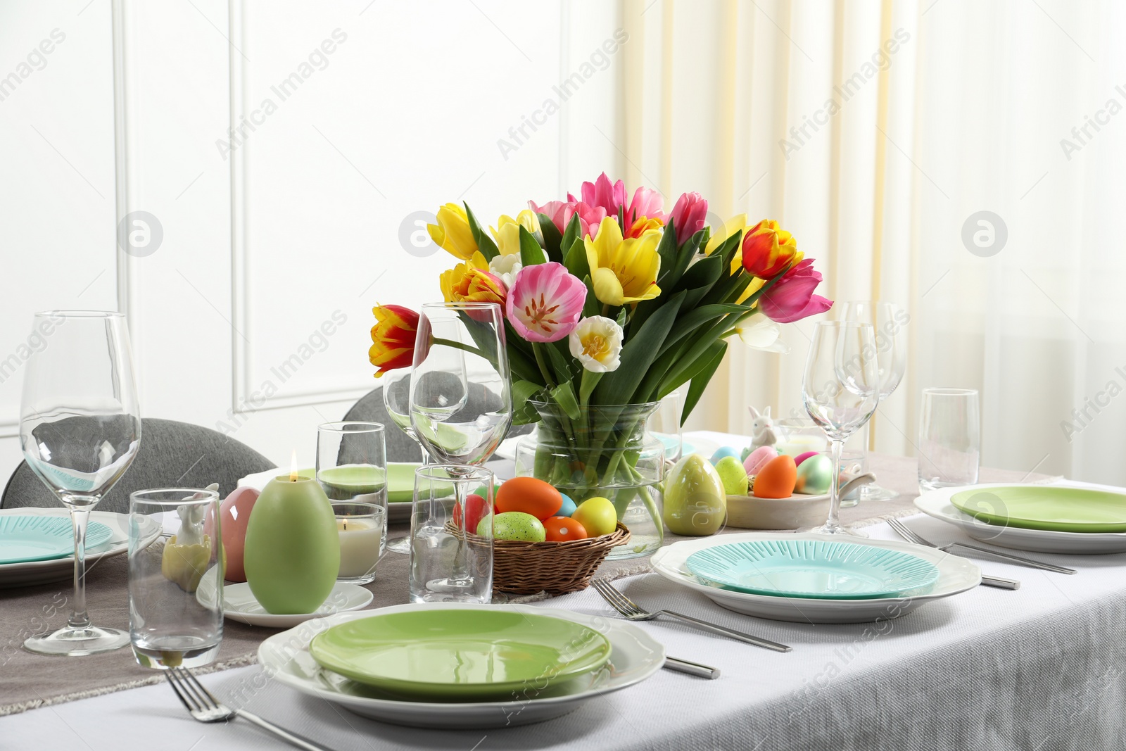 Photo of Easter celebration. Festive table setting with beautiful flowers and painted eggs