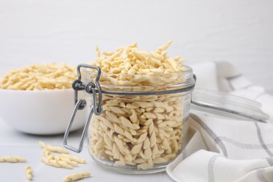 Uncooked trofie pasta on white table, closeup