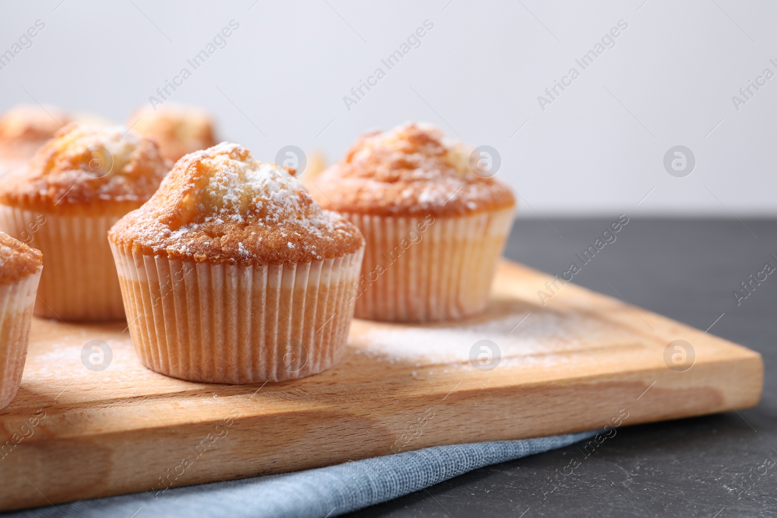 Photo of Delicious sweet muffins on black table, closeup. Space for text