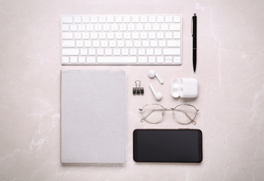 Flat lay composition with computer keyboard and smartphone on marble background