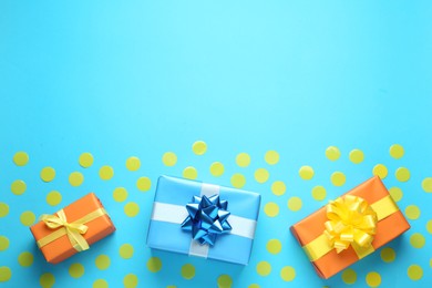 Photo of Gift boxes and confetti on light blue background, flat lay. Space for text