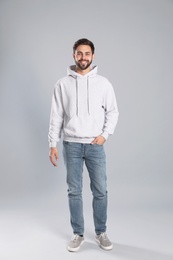 Photo of Full length portrait of young man in sweater on grey background. Mock up for design