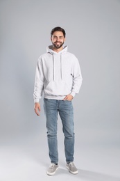 Full length portrait of young man in sweater on grey background. Mock up for design