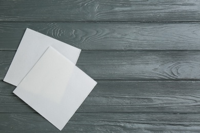 Clean napkins on grey wooden table, flat lay. Space for text