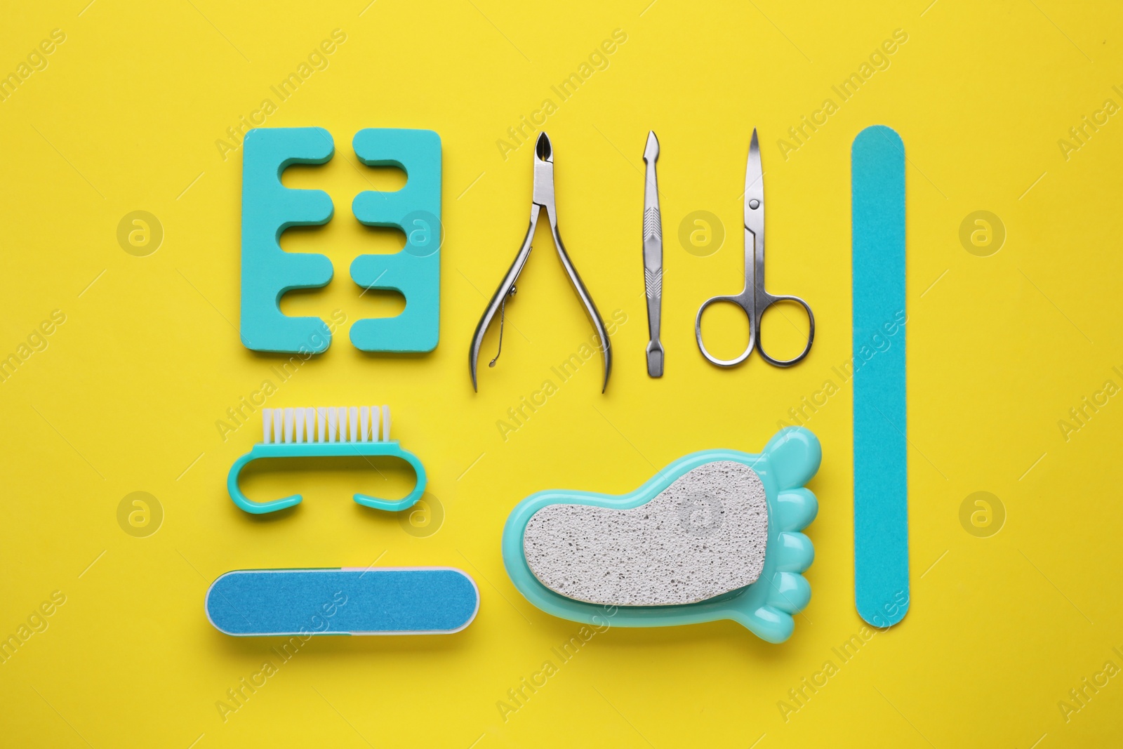Photo of Set of pedicure tools on yellow background, flat lay