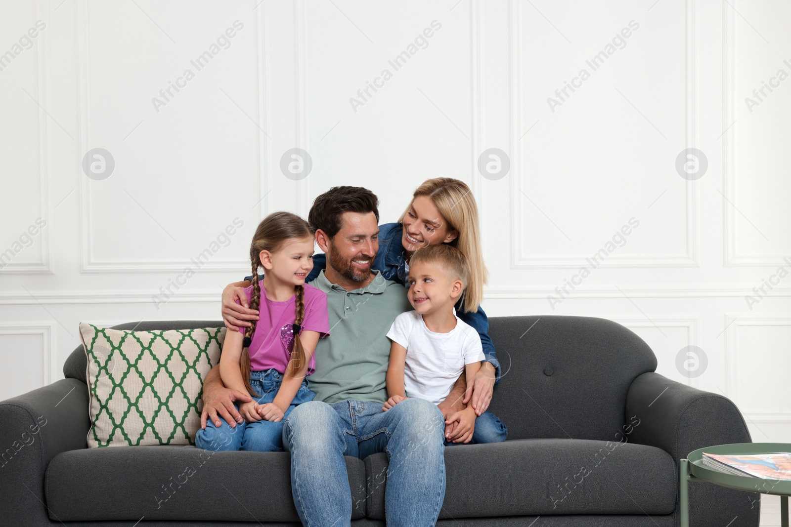 Photo of Happy family spending time together on sofa at home