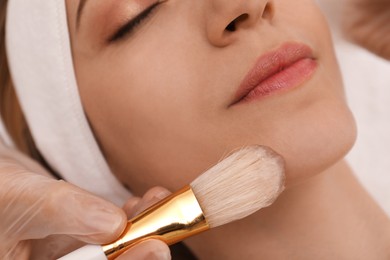 Photo of Young woman during face peeling procedure in salon, closeup