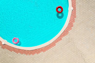 Inflatable rings floating in swimming pool, top view. Summer vacation