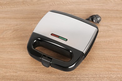 Photo of Modern electric sandwich maker on wooden table