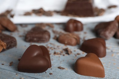 Photo of Beautiful heart shaped chocolate candies on wooden table, closeup