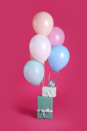Gift boxes and balloons near bright pink ​background