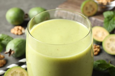 Photo of Freshly made feijoa smoothie in glass on table, closeup