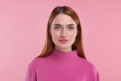 Portrait of young woman on pink background
