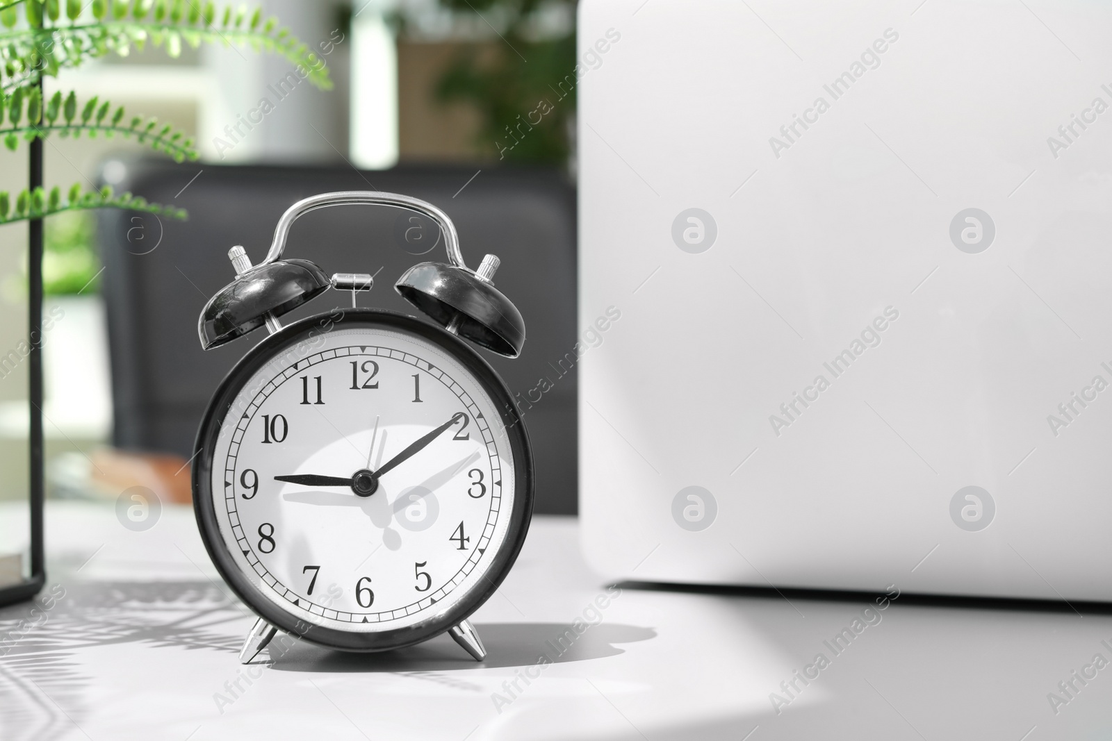 Photo of Alarm clock on table in office. Time to work