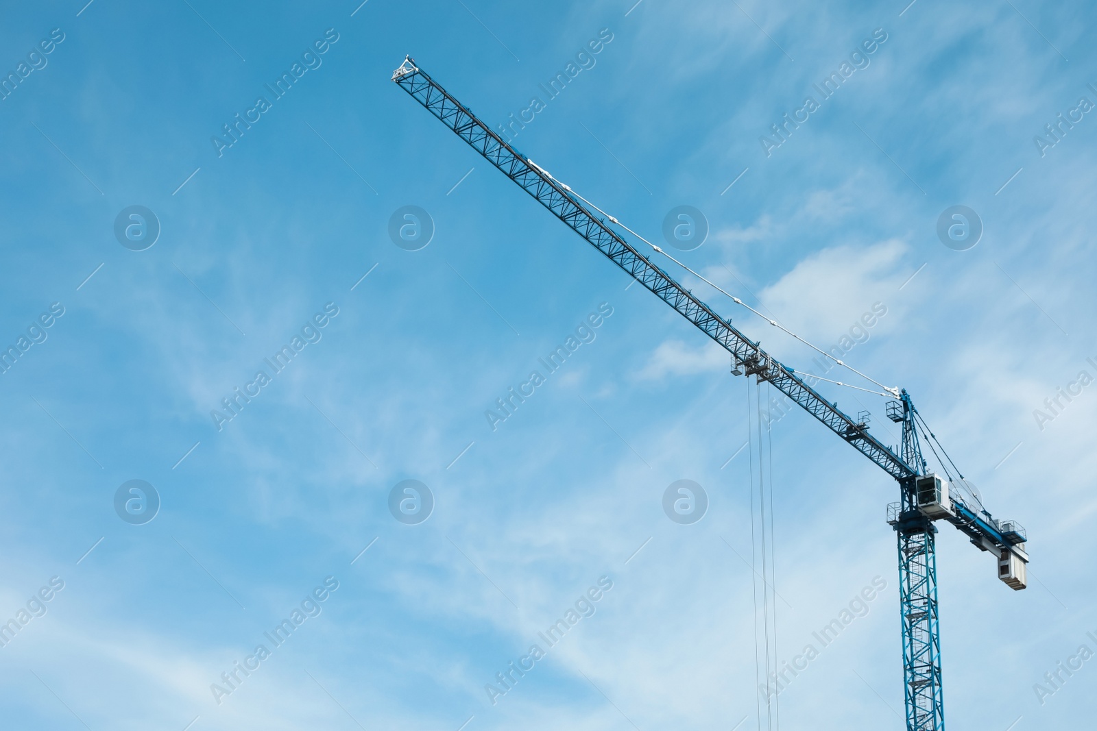 Photo of Tower crane against cloudy sky, low angle view