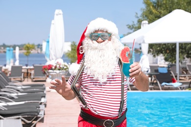 Authentic Santa Claus with cocktail near pool at resort