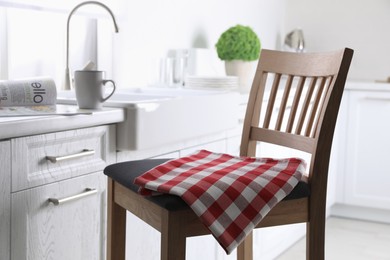 Photo of Dry towel on wooden chair in kitchen