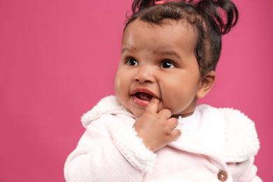 Cute African American baby on pink background