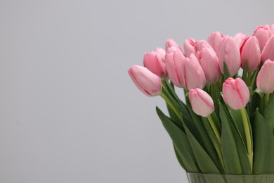 Bouquet of beautiful pink tulips on grey background, closeup. Space for text