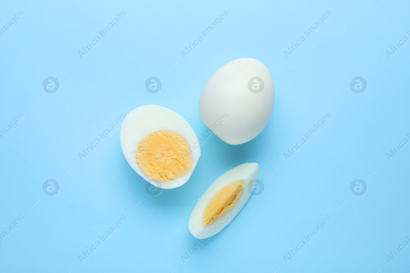 Photo of Fresh hard boiled eggs on light blue background, flat lay