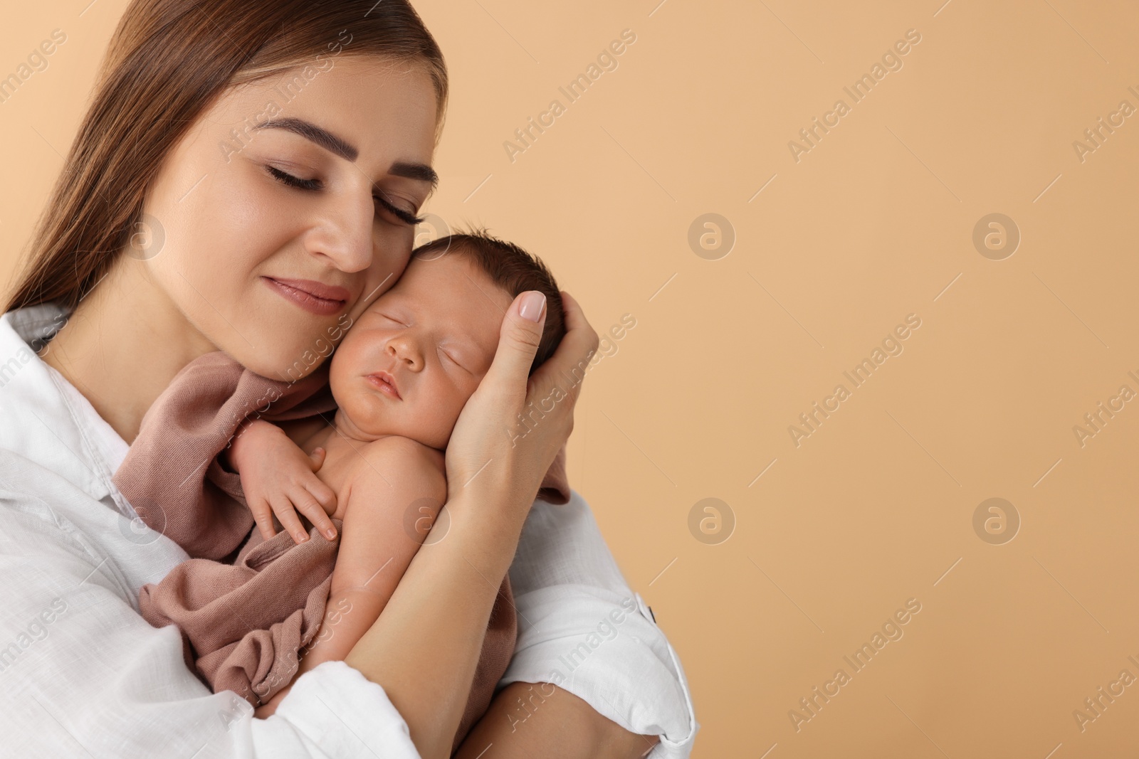 Photo of Mother with her cute newborn baby on beige background. Space for text