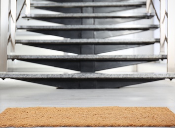 Photo of New door mat near stone stairs indoors