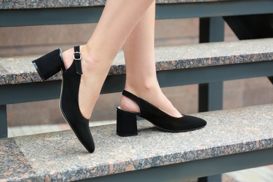 Woman in stylish shoes on stairs outdoors, closeup