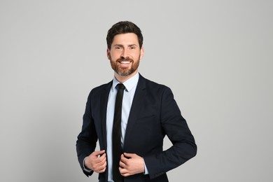 Photo of Handsome real estate agent in nice suit on grey background