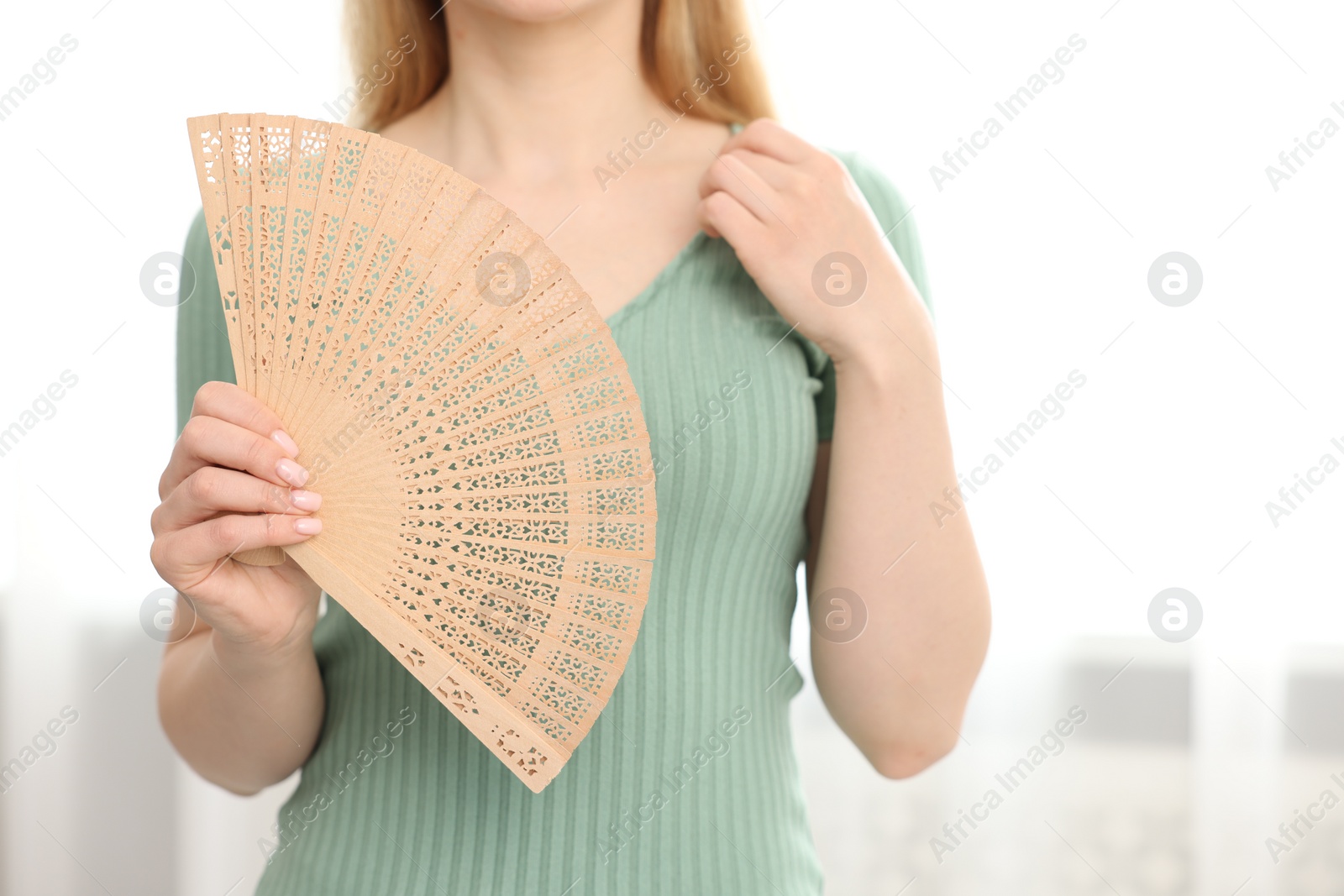 Photo of Woman with hand fan at home, closeup