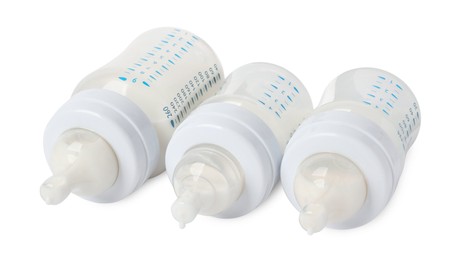 Three feeding bottles with infant formula on white background