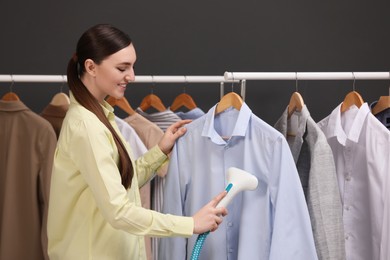 Photo of Woman steaming shirt on hanger in room