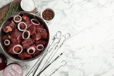 Photo of Flat lay composition with metal skewers and bowl of raw meat on white marble table, space for text