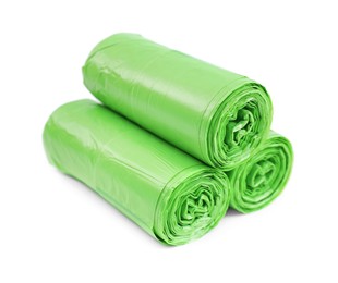 Photo of Rolls of light green garbage bags isolated on white