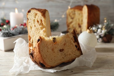 Delicious Panettone cake with raisins on light wooden table, closeup. Traditional Italian pastry