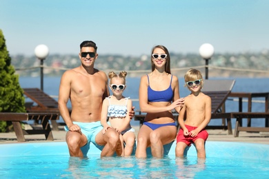 Photo of Happy family at poolside on sunny summer day
