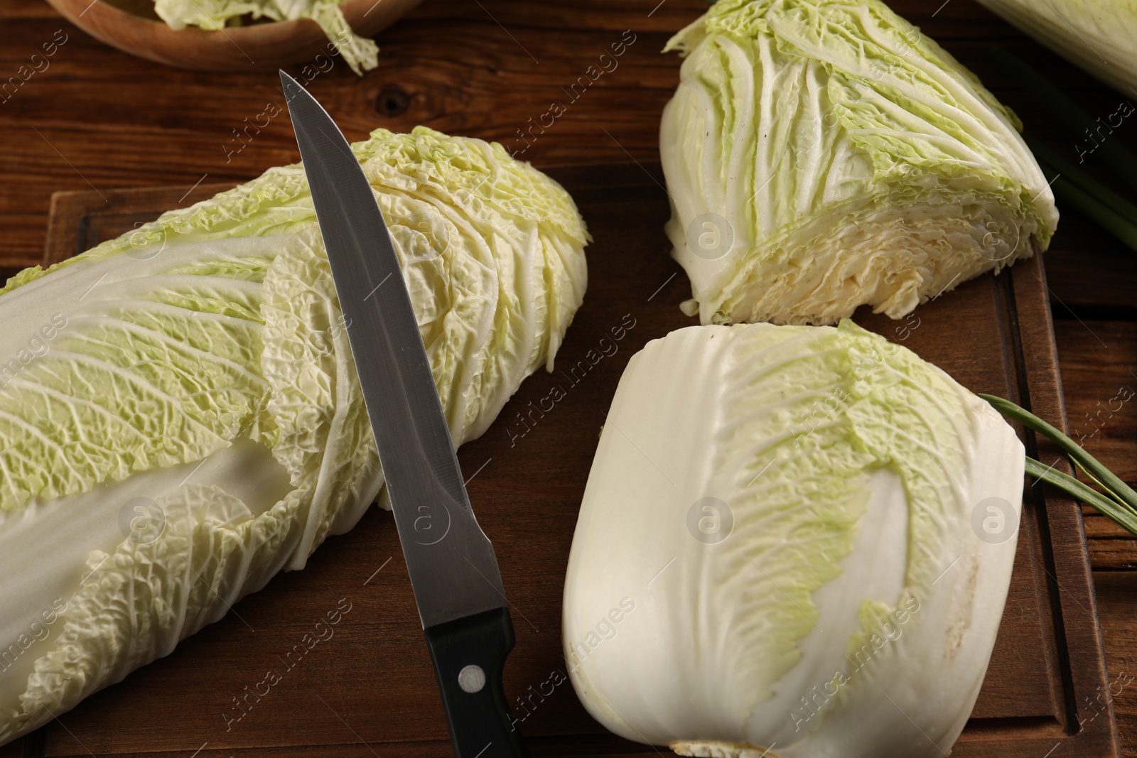 Photo of Whole and cut fresh Chinese cabbages on wooden table