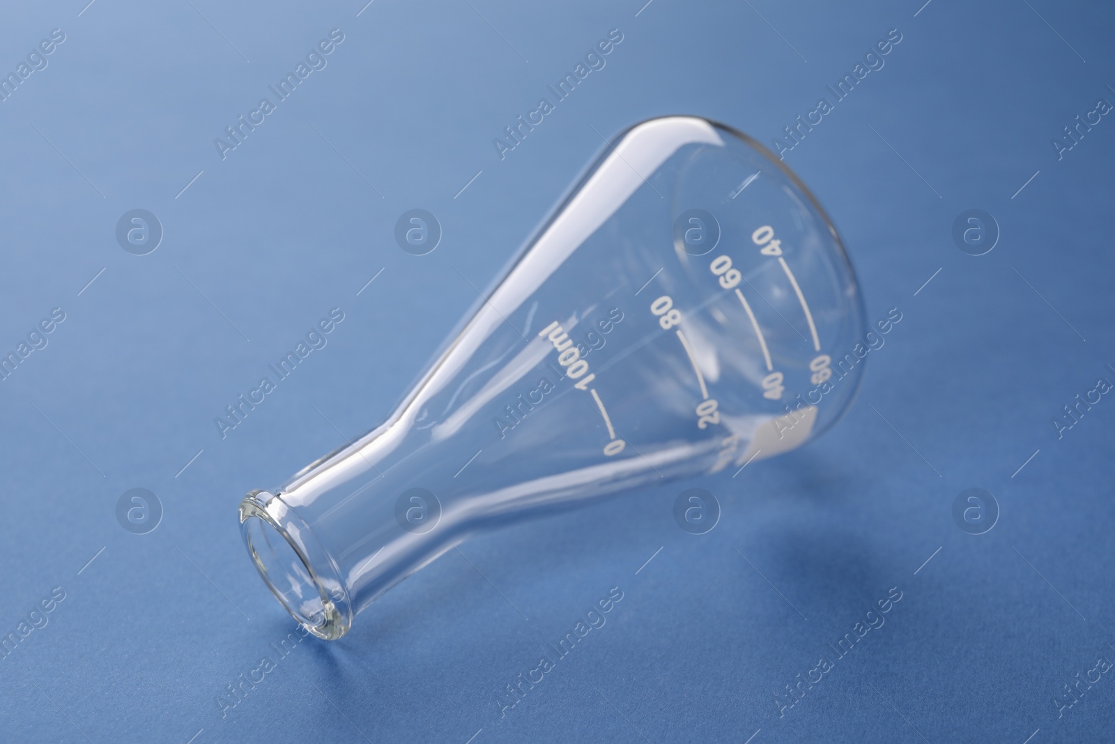Photo of One flask on blue background. Laboratory glassware