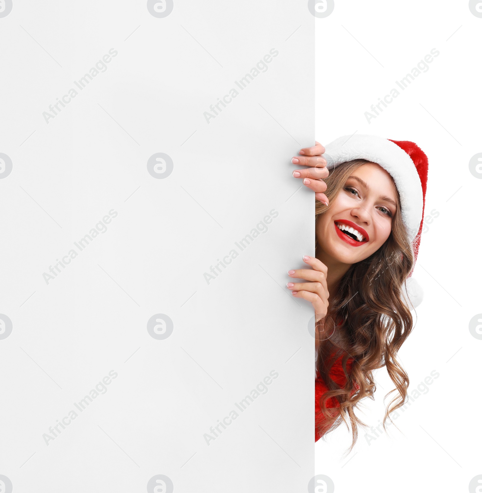 Photo of Beautiful Santa girl peeping out of blank banner on white background. Christmas celebration