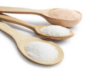 Photo of Different types of natural salt in wooden spoons isolated on white