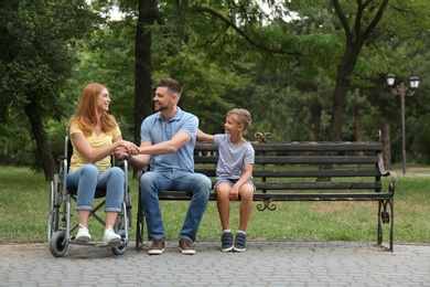 Photo of Woman in wheelchair with her family at park
