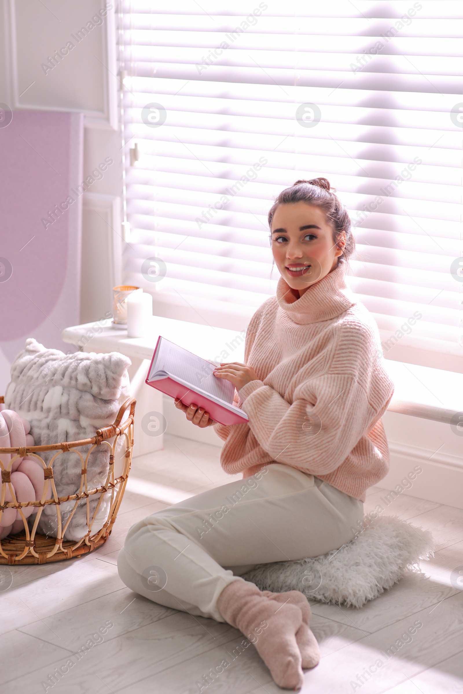 Photo of Beautiful young woman with book relaxing at home. Cozy atmosphere