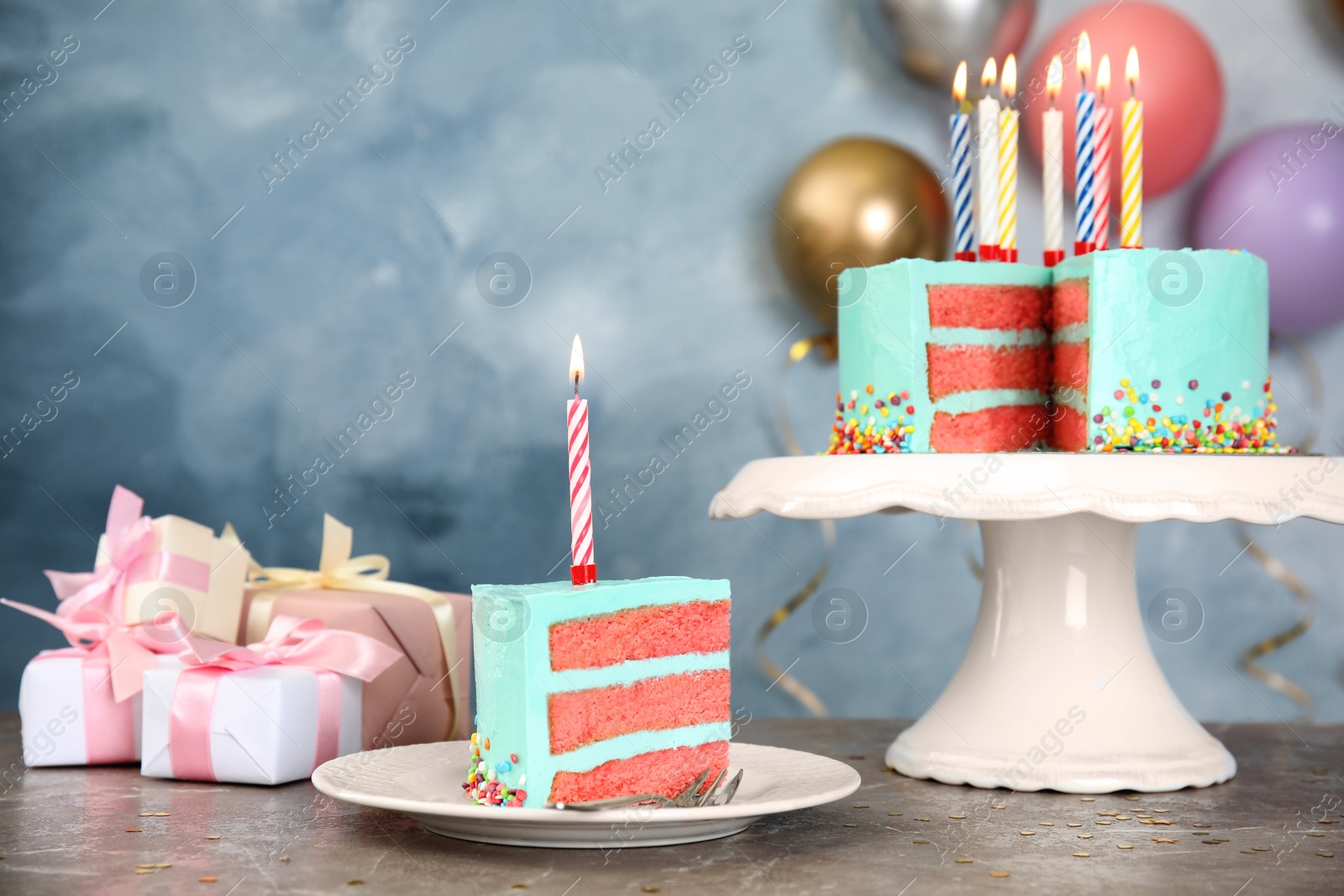 Photo of Fresh delicious cake with candles and gifts on table against color background