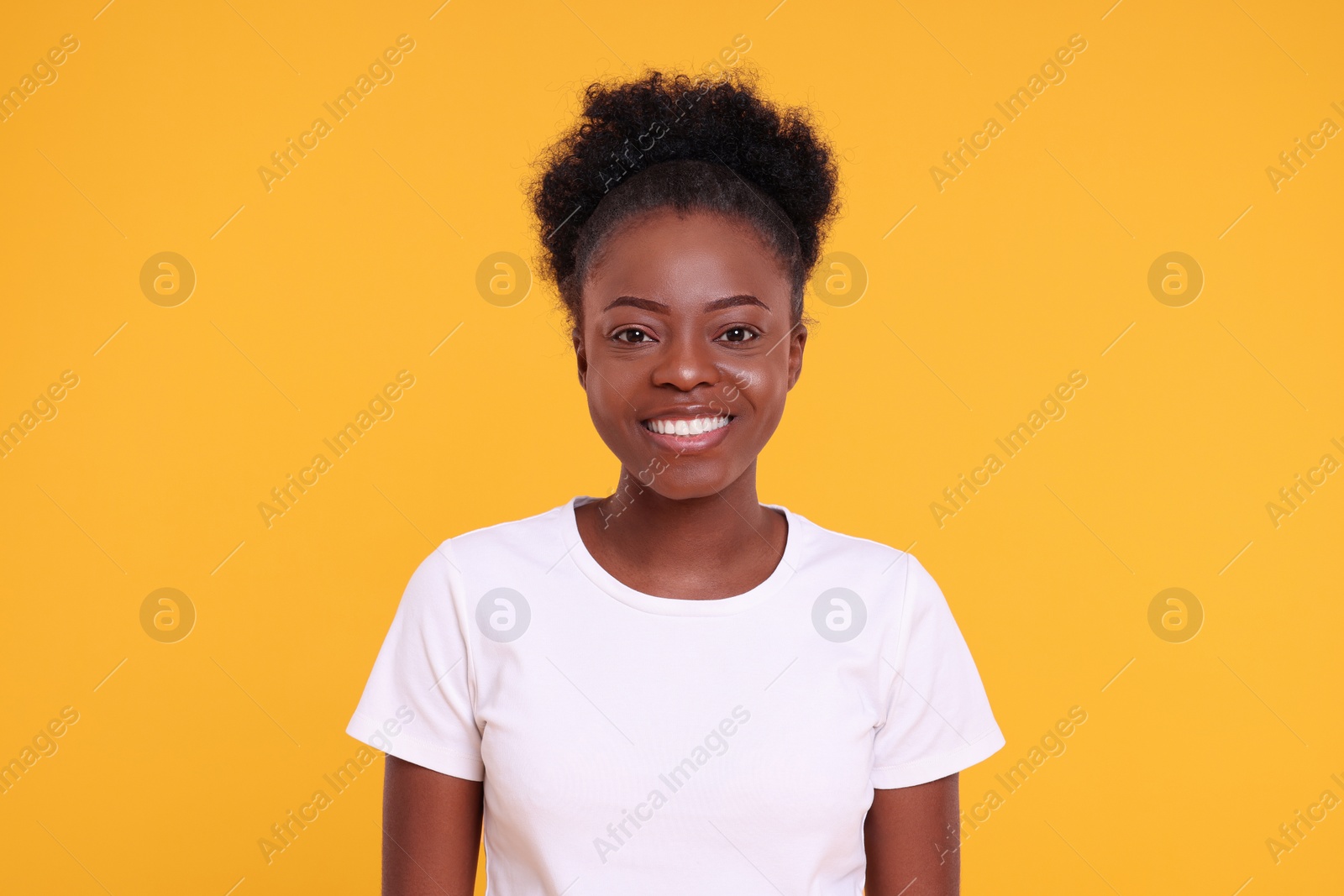 Photo of Portrait of happy young woman on orange background