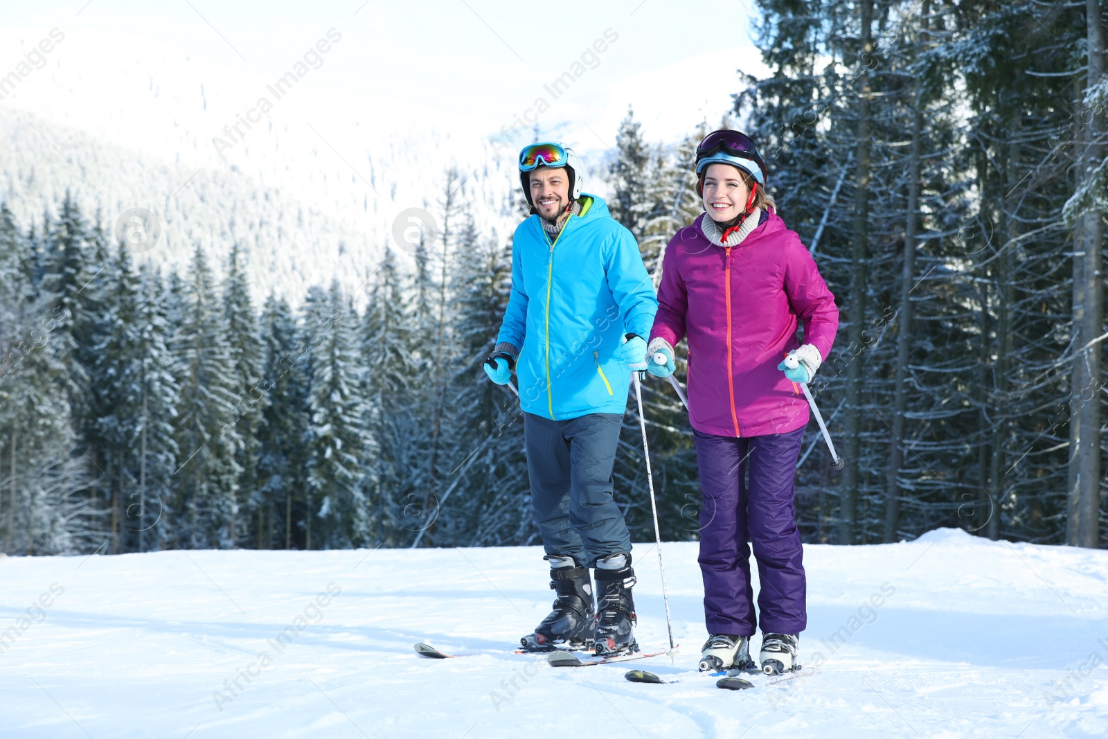 Photo of Happy couple with ski equipment spending winter vacation in mountains