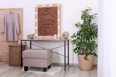 Photo of Stylish room interior with dressing table and potted ficus