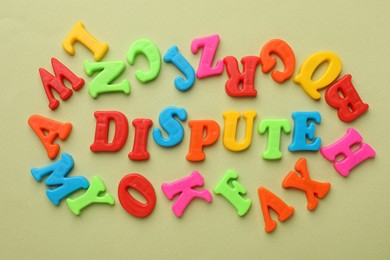 Photo of Word Dispute made of colorful letters on light green background, flat lay