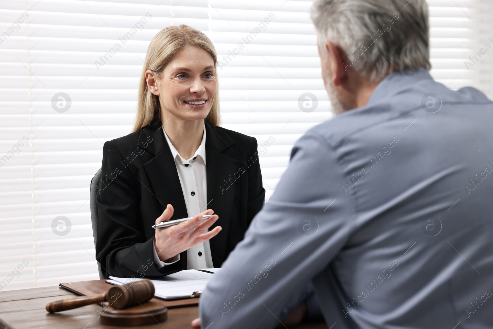 Photo of Senior man having meeting with lawyer in office