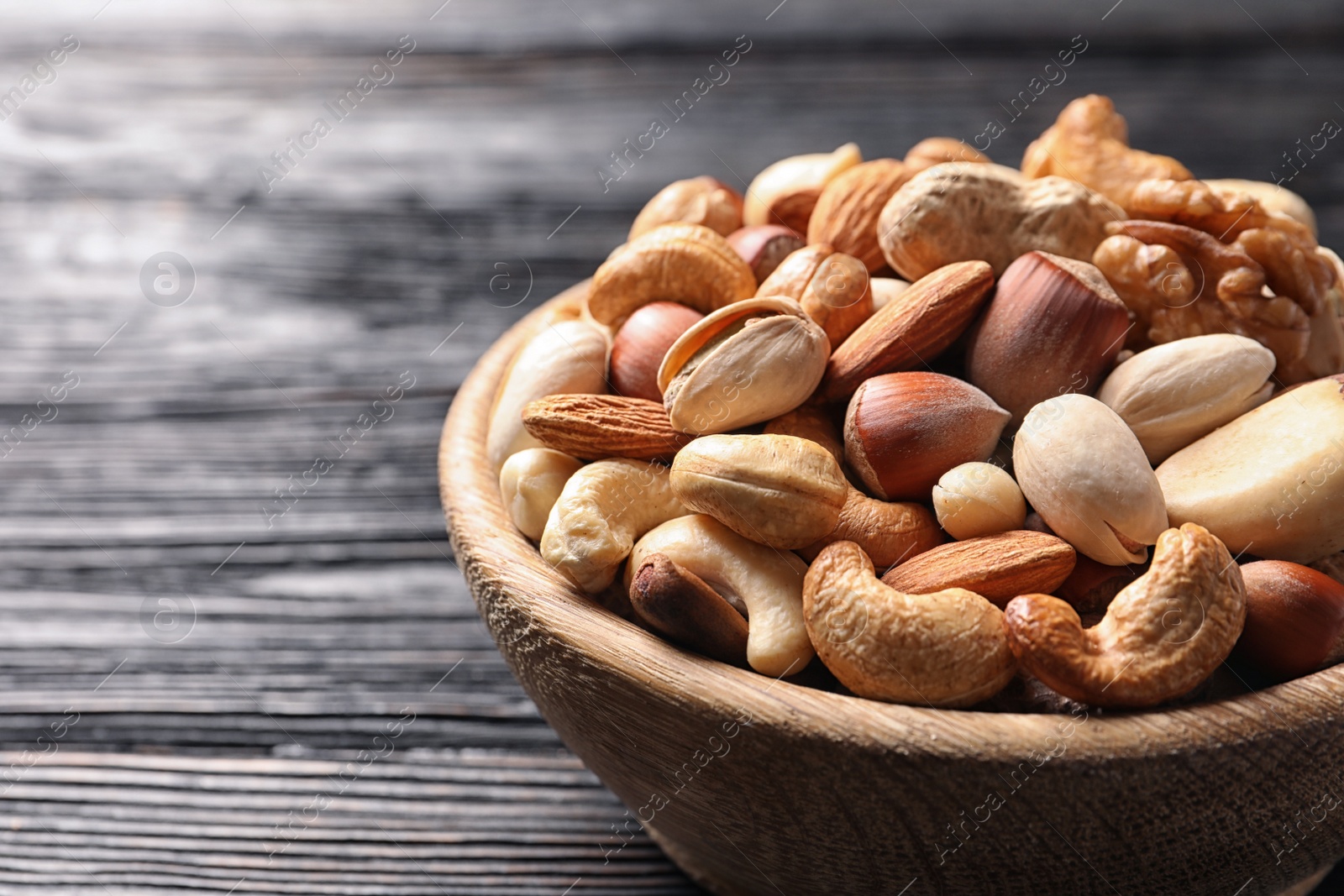 Photo of Bowl with organic mixed nuts on table, closeup